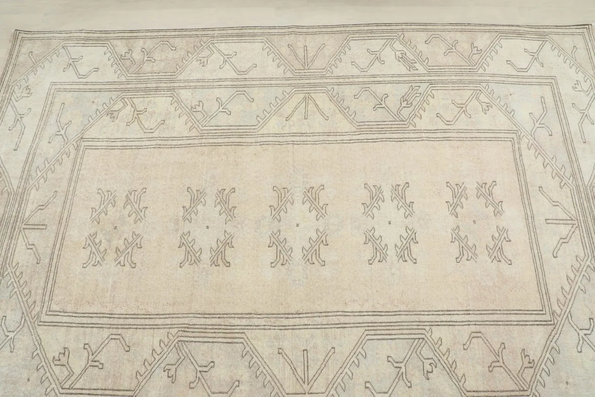 Overhead close-up of the central field and part of the border, revealing the subtle variations in the beige and gray tones.