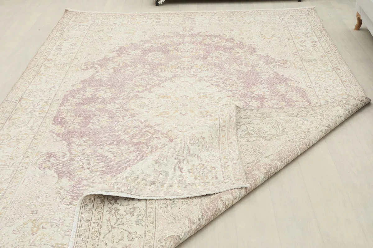 The rug partially folded to demonstrate its flexibility and the quality of its vintage wool material