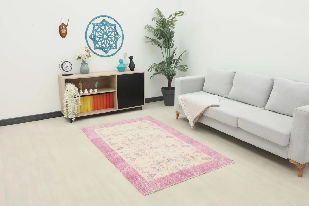 Vintage Anatolian rug in a living room setting, placed in front of a sofa and cabinet