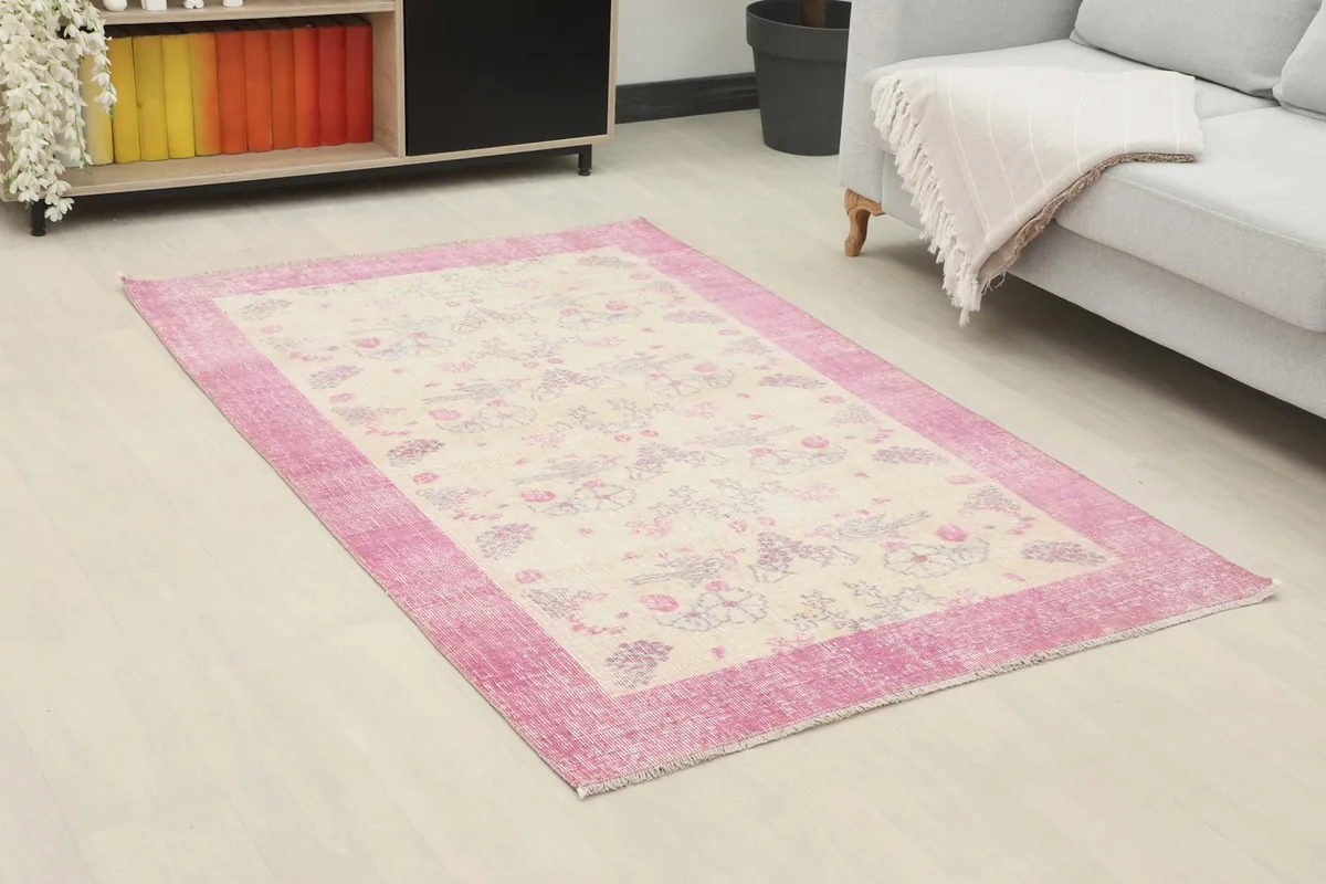 Angle view of the ivory and rose rug in a room, highlighting its placement and colors