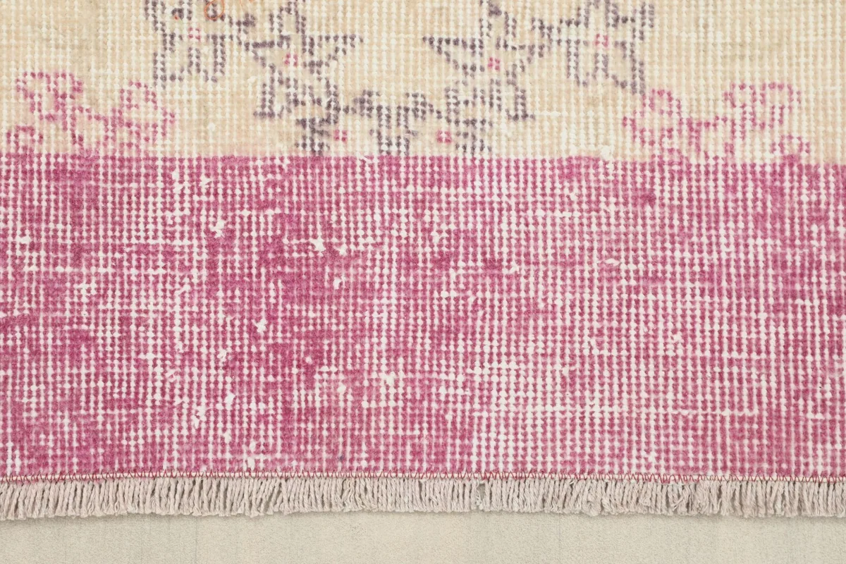 Close-up of the rug's distressed rose border and short fringes