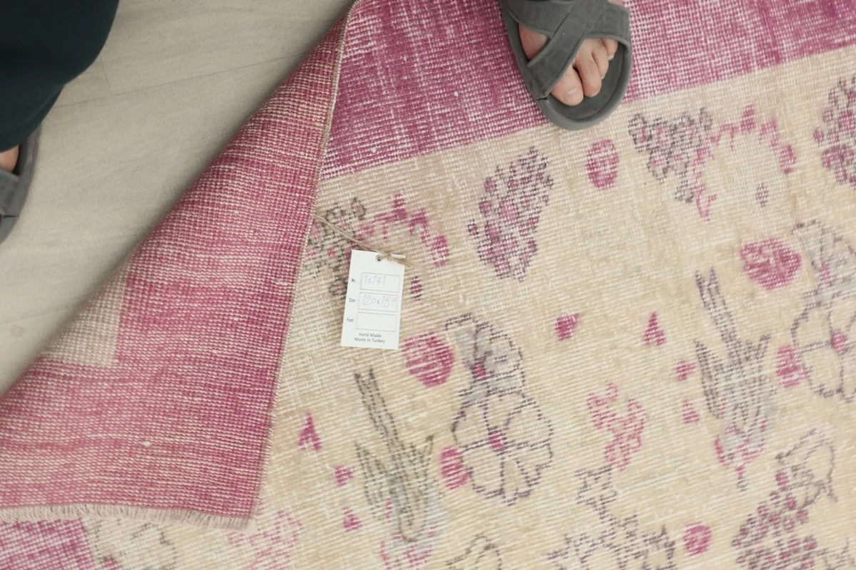 Close-up of the rug's reverse side, showing the hand-knotted construction and a small label