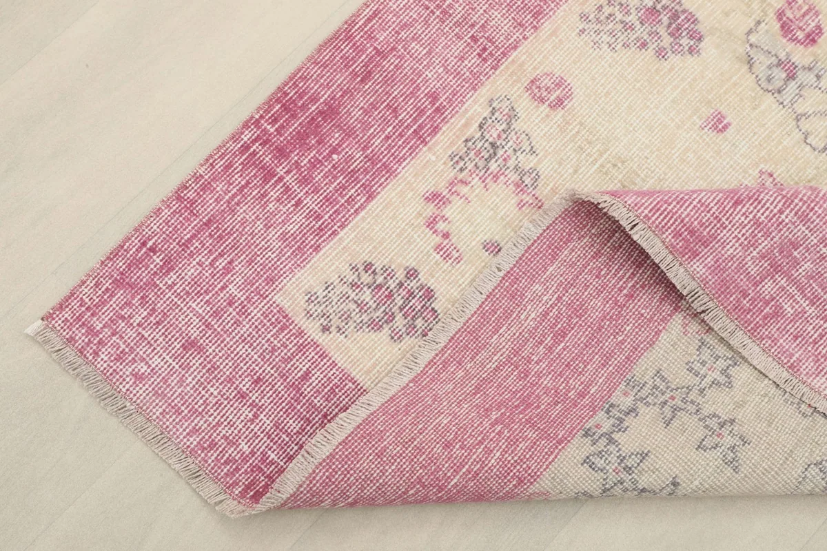 Corner of the rug folded back to show the cotton foundation and reverse side