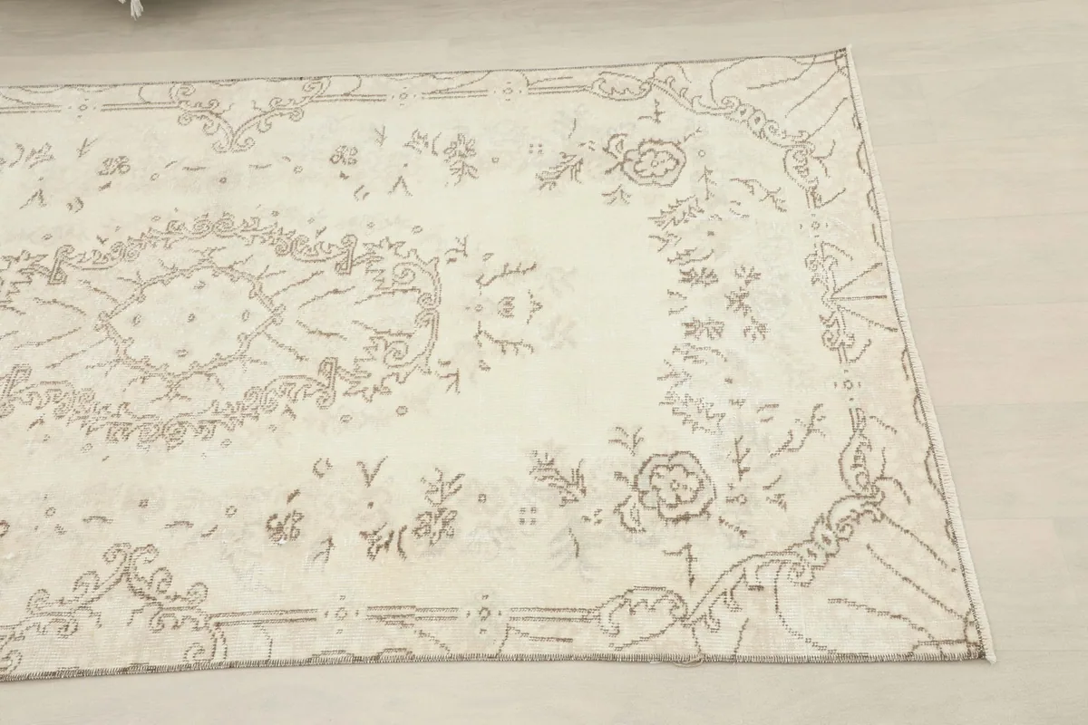 Close-up of the upper right section of the ivory rug, highlighting the floral border design
