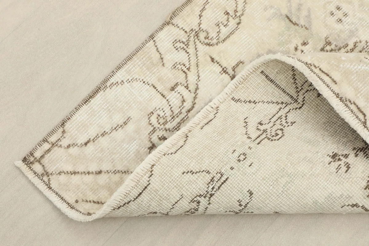 Corner of the rug folded to reveal the hand-knotted cotton foundation and reverse side
