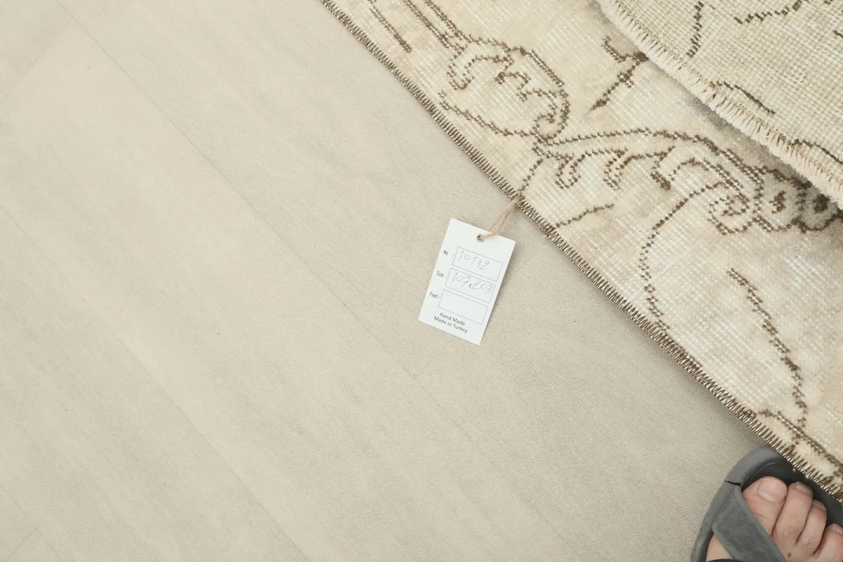 Detail showing the care tag next to the rug, indicating professional cleaning and material
