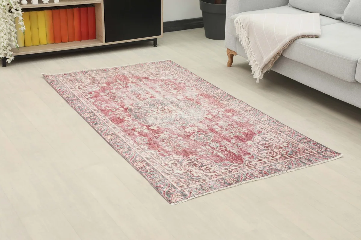 Angle view of the red and gray vintage rug in a living room, showing its placement on the floor