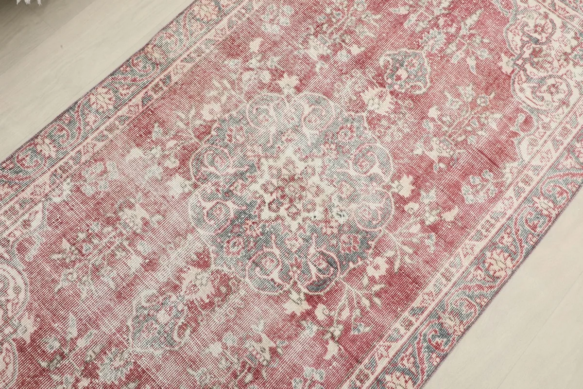 Overhead view focusing on the central medallion and surrounding floral patterns of the red and gray rug