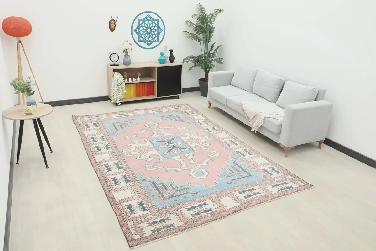 Vintage pink and blue Anatolian rug placed in a modern living room setting