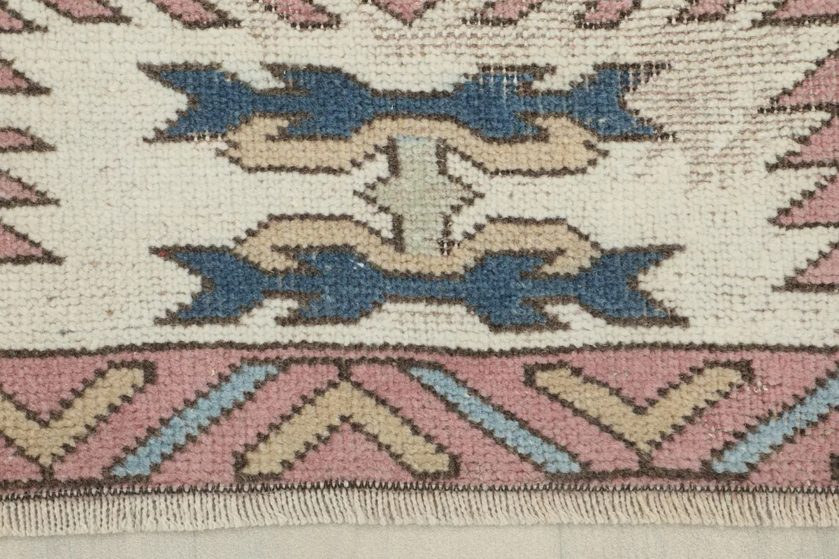 Detailed view of the ivory border with navy and beige geometric elements