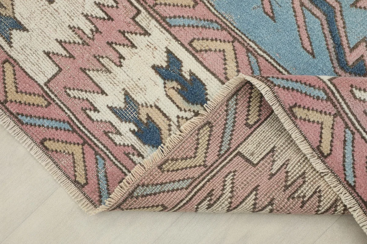 Folded corner of the rug, revealing the wool pile and cotton foundation