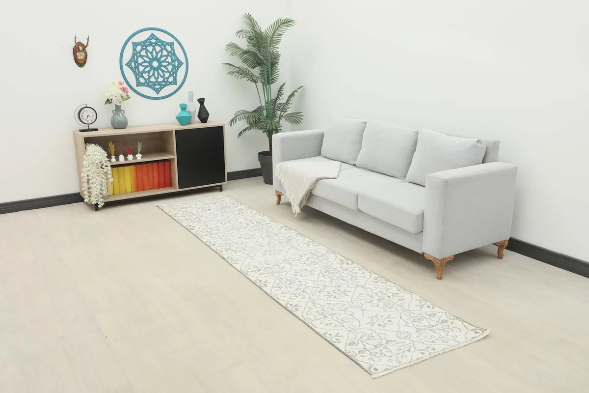 Ivory and gray runner rug placed in a modern living room setting with a light gray sofa