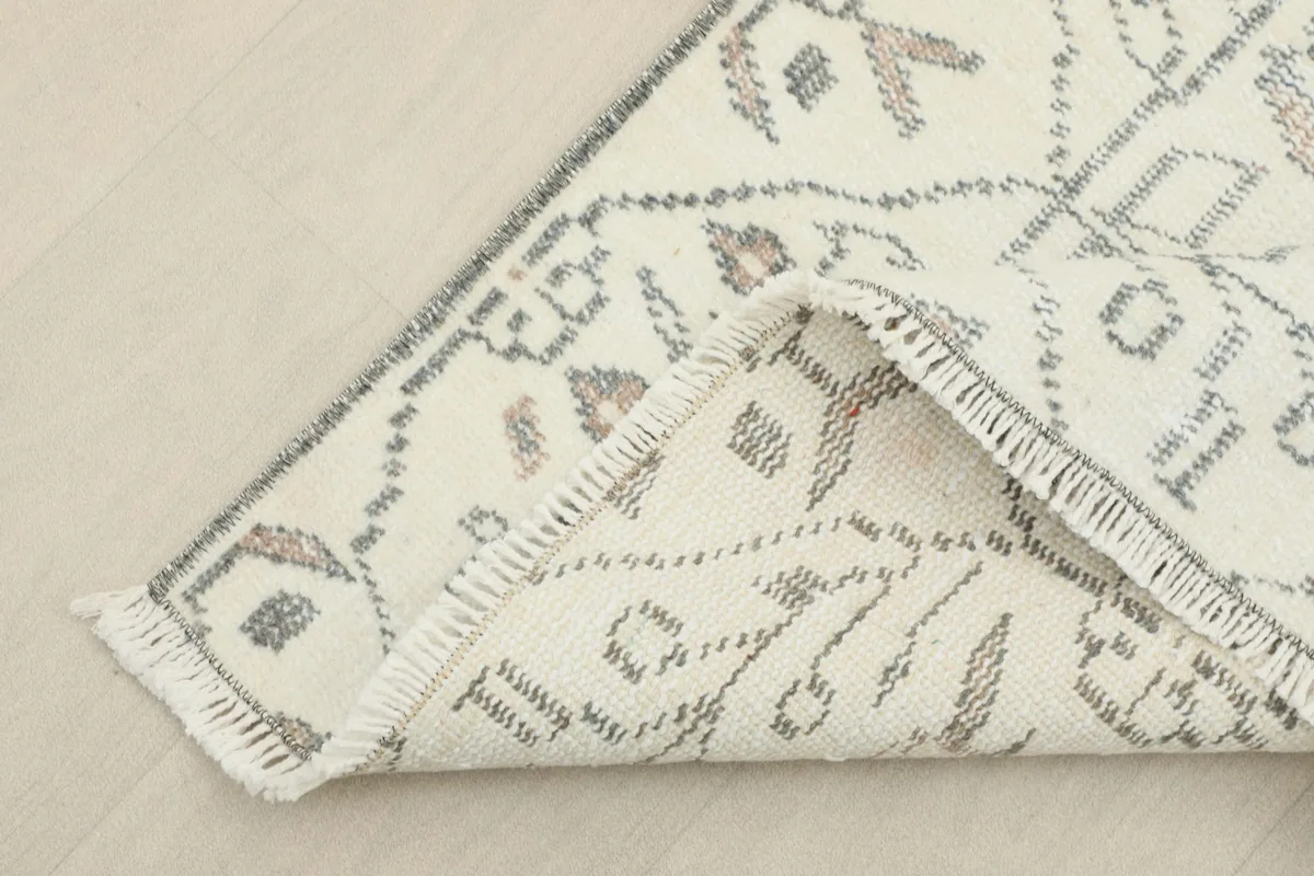 Corner of the rug folded to show the hand-knotted back and foundation
