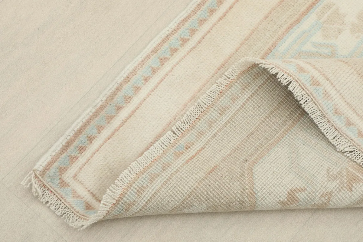 Corner folded back to show the cotton foundation and the reverse side of the hand-knotted weave.