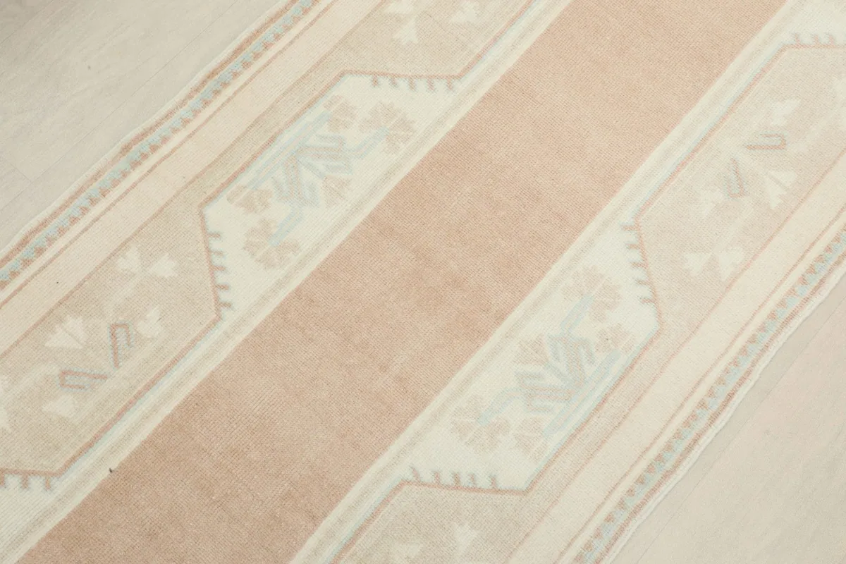 Overhead view focusing on the central rose stripe and surrounding beige geometric patterns.
