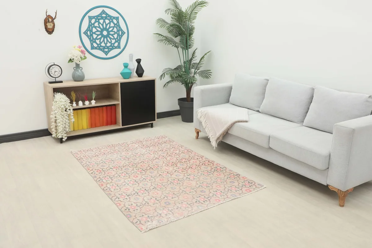 Area rug in a living room setting with a light gray sofa and wooden cabinet, showing its scale.