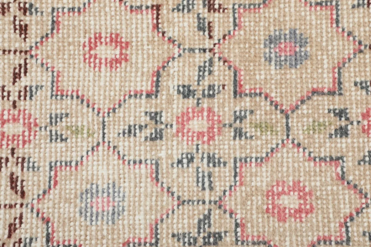 Detailed close-up of the hand-knotted wool pile, showing individual knots and color blend of pink, blue, and green.