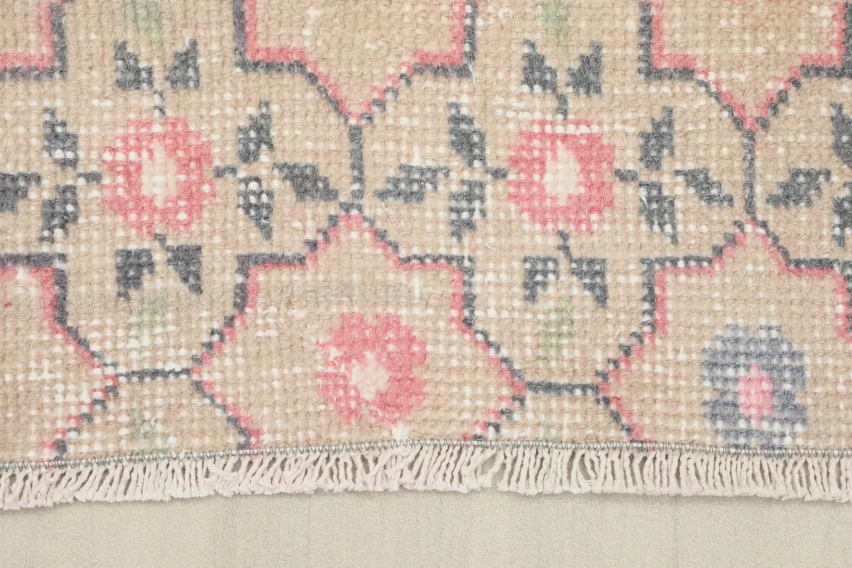 Close-up of the rug's edge, showing the short fringe and the intricate pattern near the border.