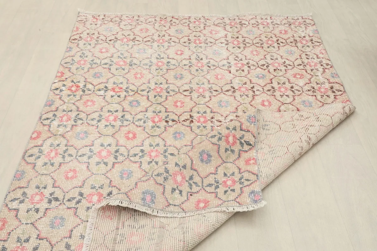 Partial fold of the rug, showing the back of the rug and the tightly woven cotton foundation.