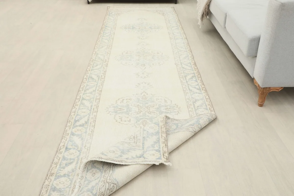 Angled view of the runner partially unrolled in a room, emphasizing its long shape.