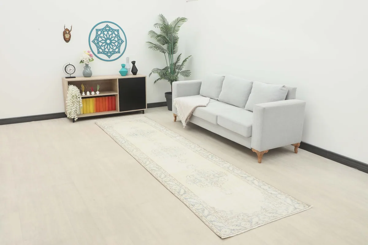 Ivory and blue runner rug laid in a modern living space with a sofa and decor.