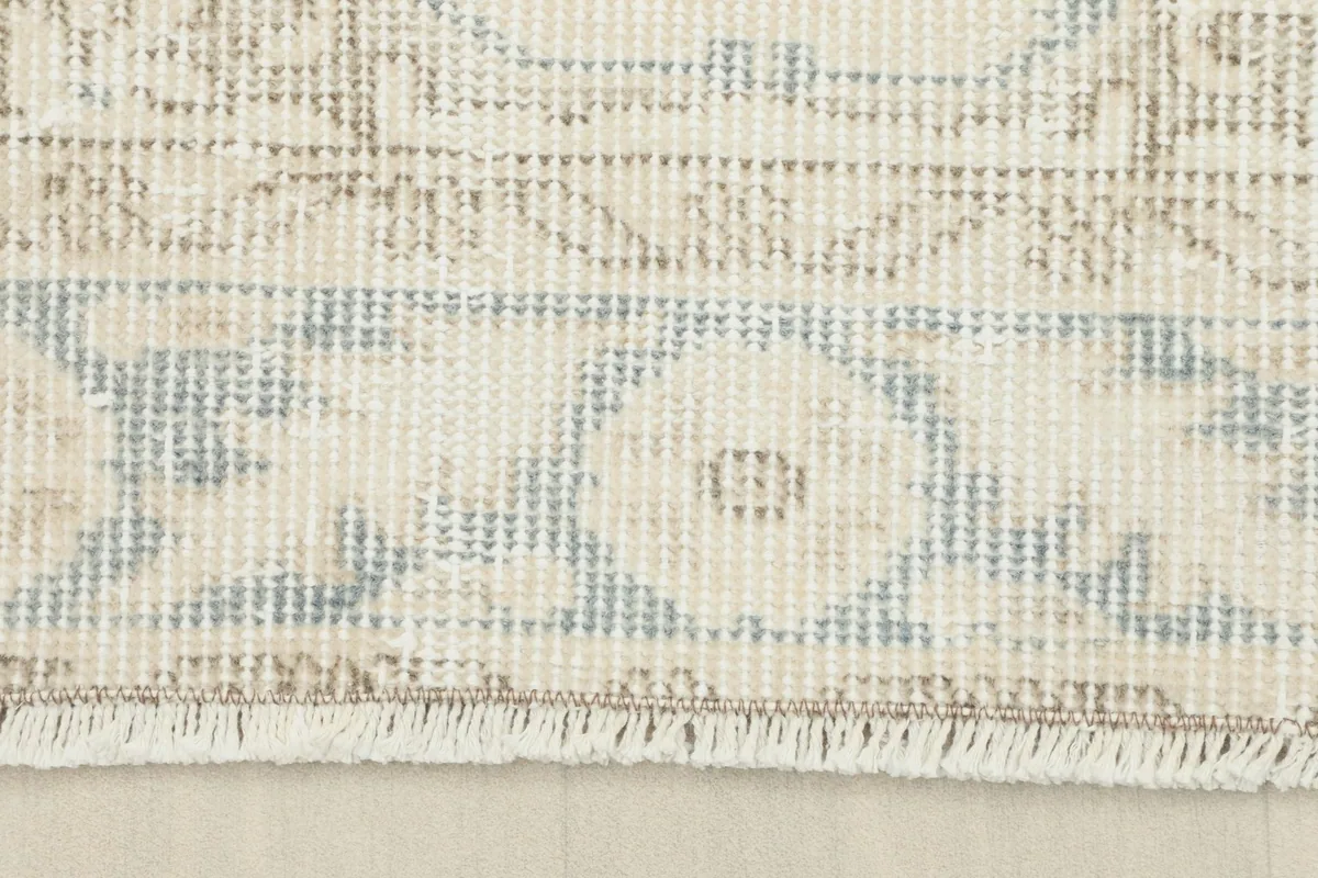 Close-up of the rug's end, showing the short, natural fringe and border design.