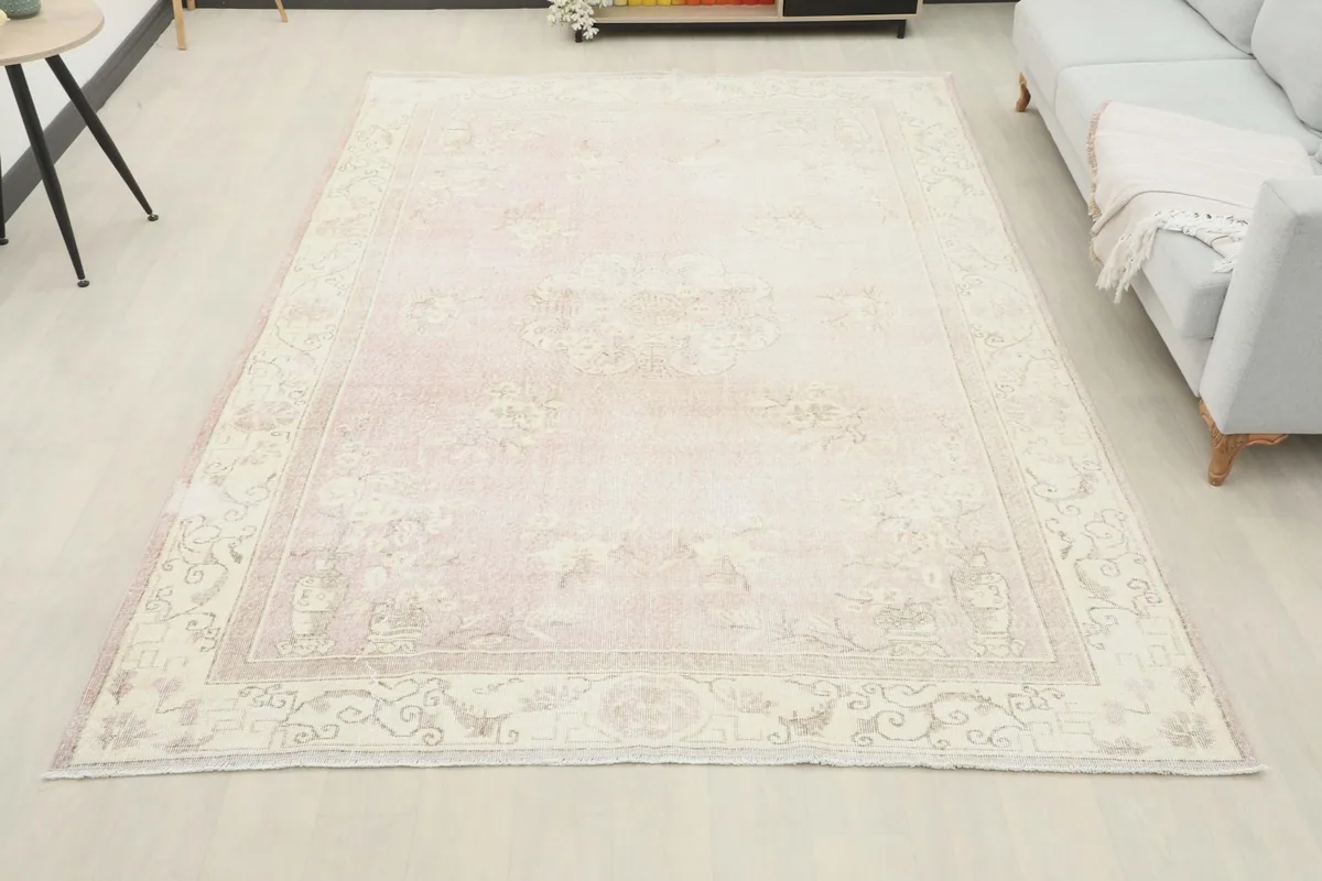 Full room view of the large vintage rose rug grounding the living space with a sofa.