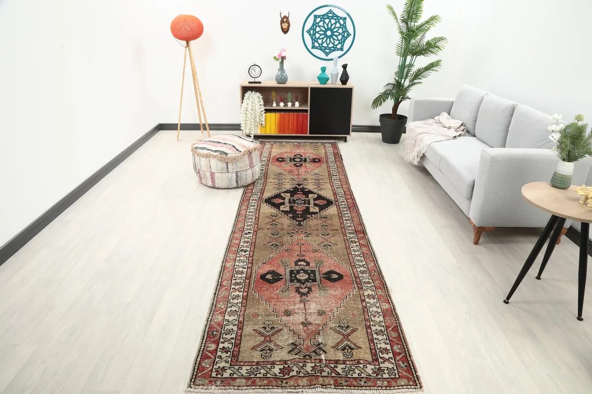 Vintage runner rug displayed in a modern living space with a couch and decor, showing its length and scale.