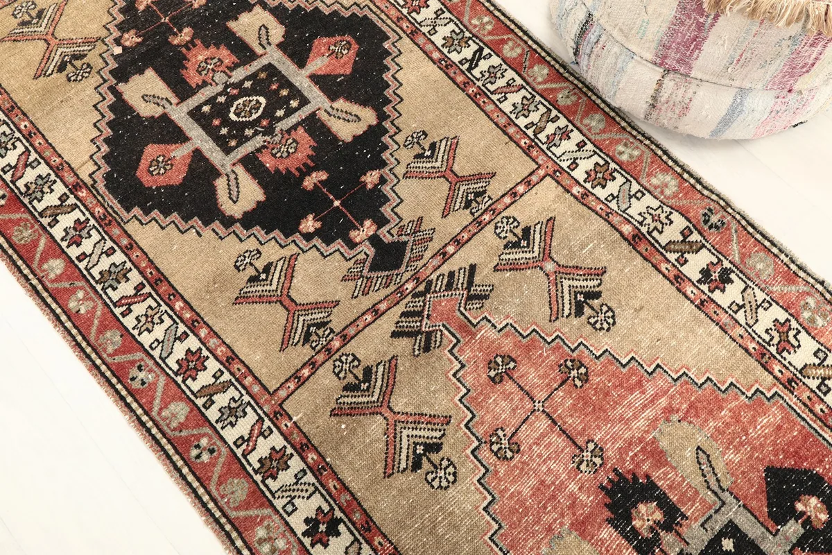 Detailed view of the central geometric motifs in red, tan, and charcoal, highlighting the weave.