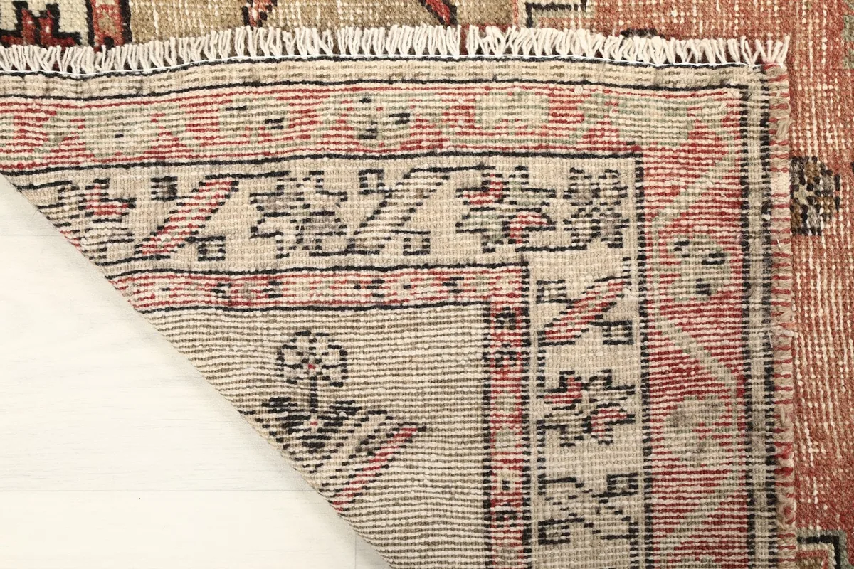 Close-up of the rug's back, showing the hand-knotted construction and cotton foundation.