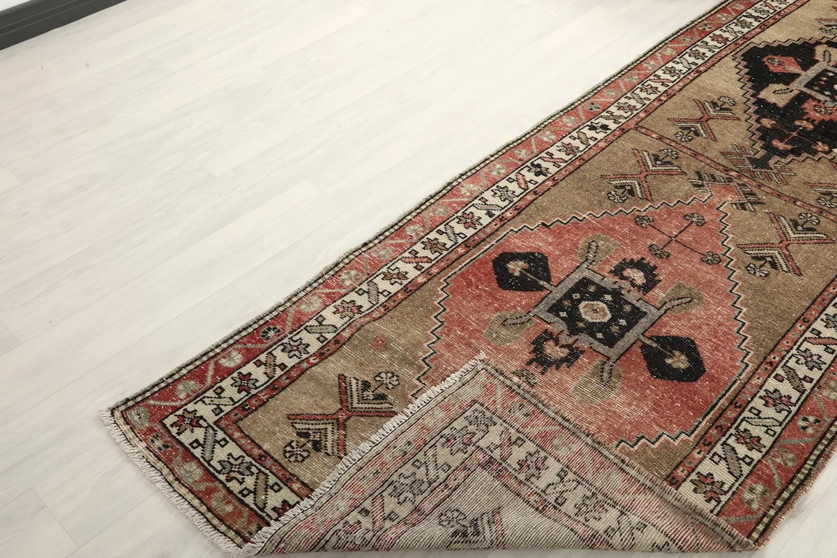 View of the rug folded back on itself, revealing the cotton foundation and the reverse side.