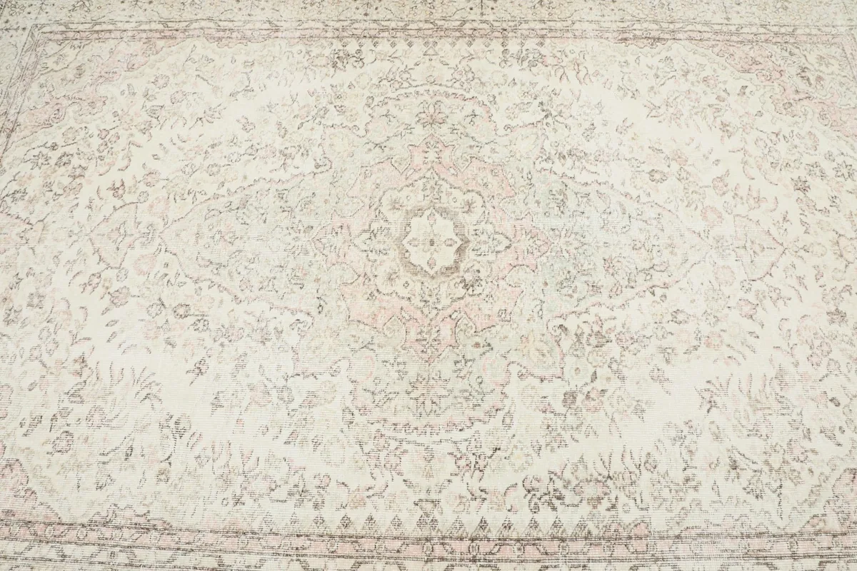 Detailed view of the central medallion design and surrounding floral elements.