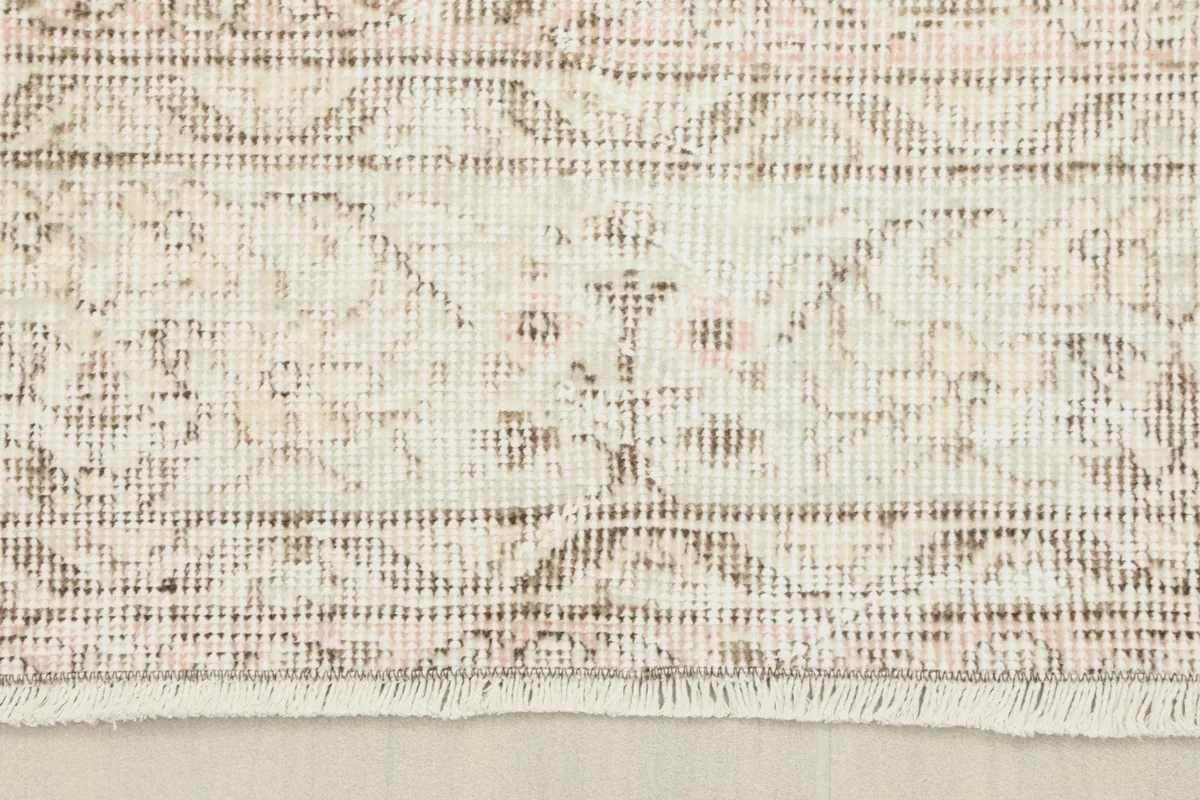 Detailed shot of the rug's border design and short fringe.