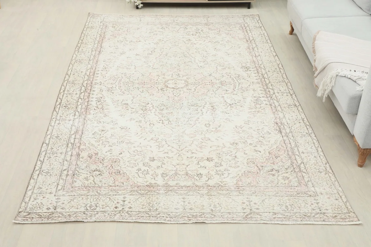 Overhead view of the vintage rug laid out in a room, demonstrating its large size and placement.