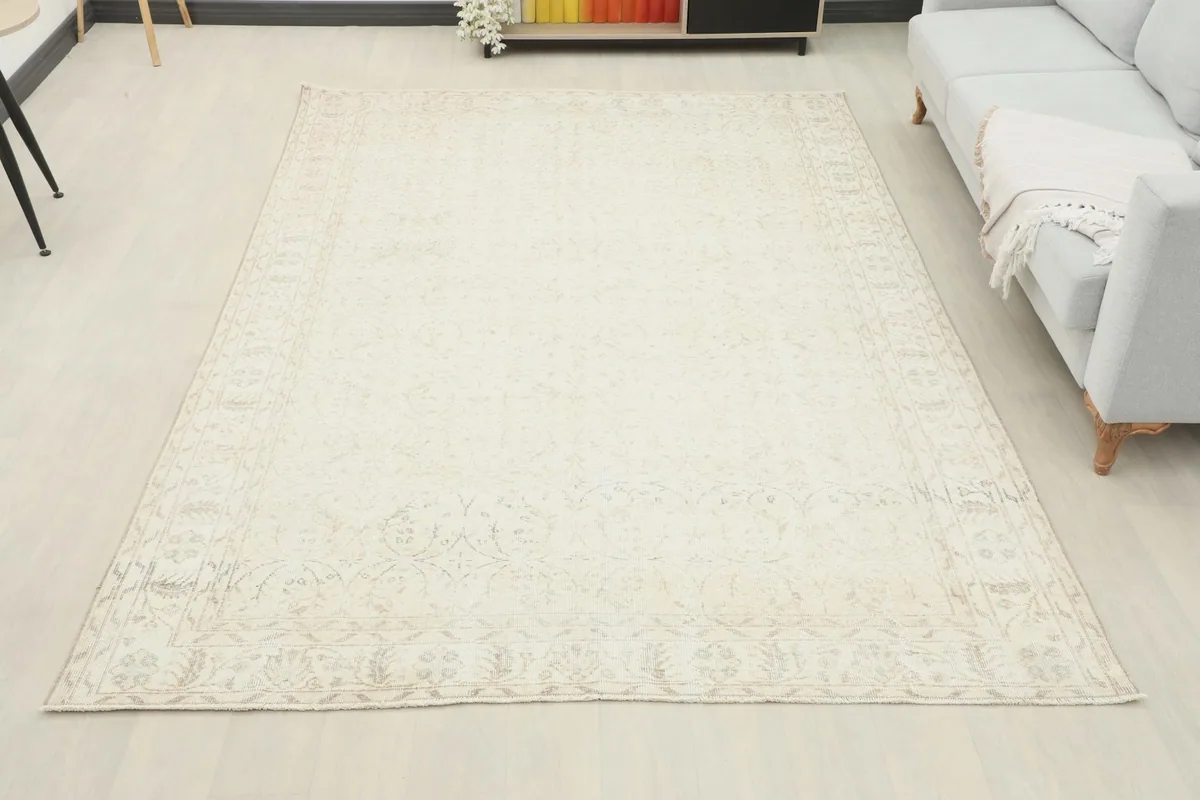 Full room view of the large cream and beige vintage rug, showcasing its overall appearance and scale