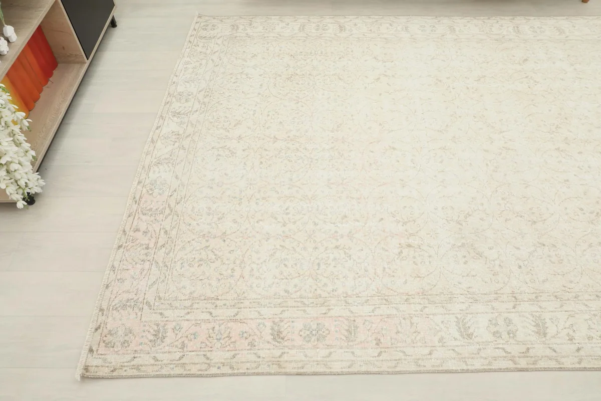 Detailed view of another corner of the rug, showing the faded patterns and soft color variations