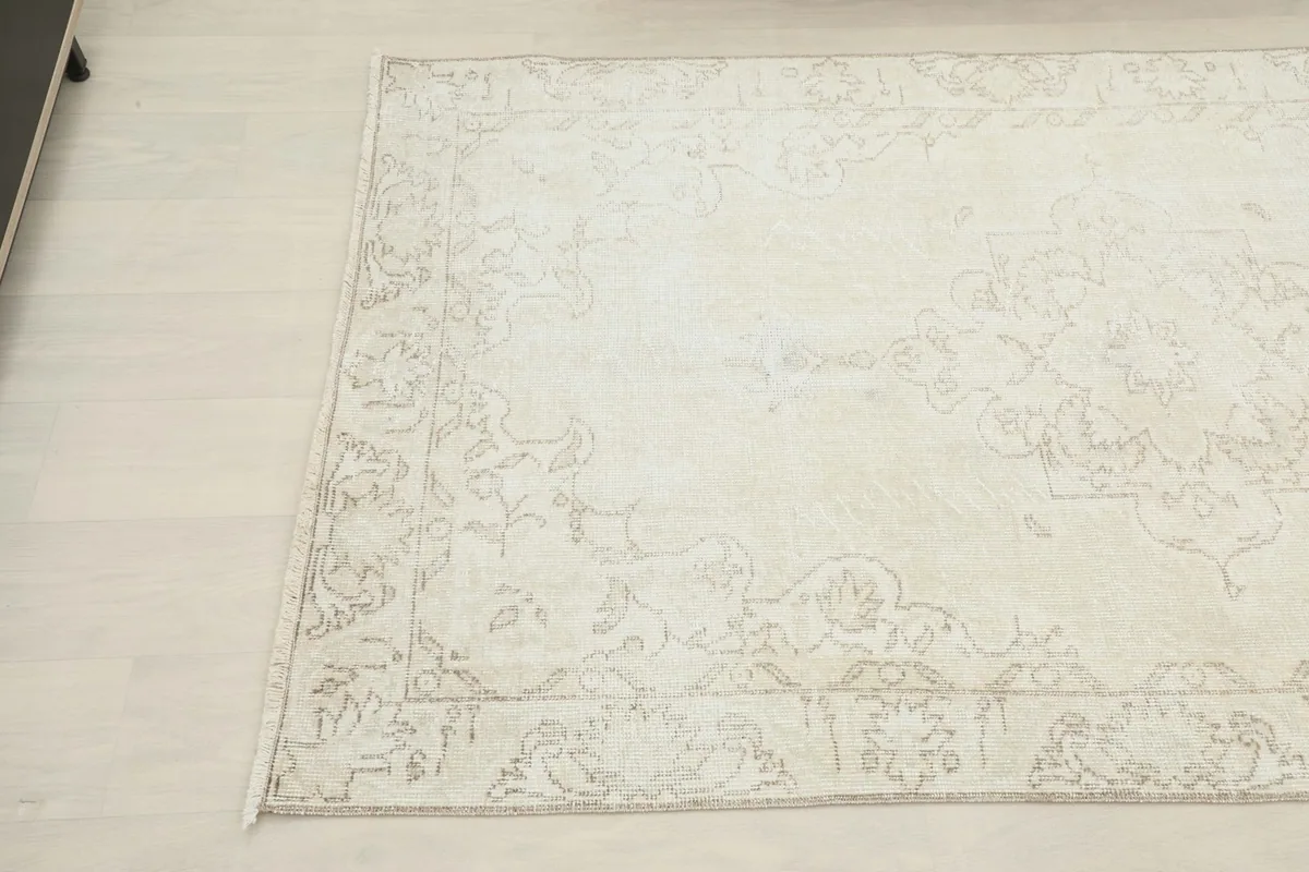 Another angle shot of the ivory beige rug, showing its rectangular shape and soft color variations.