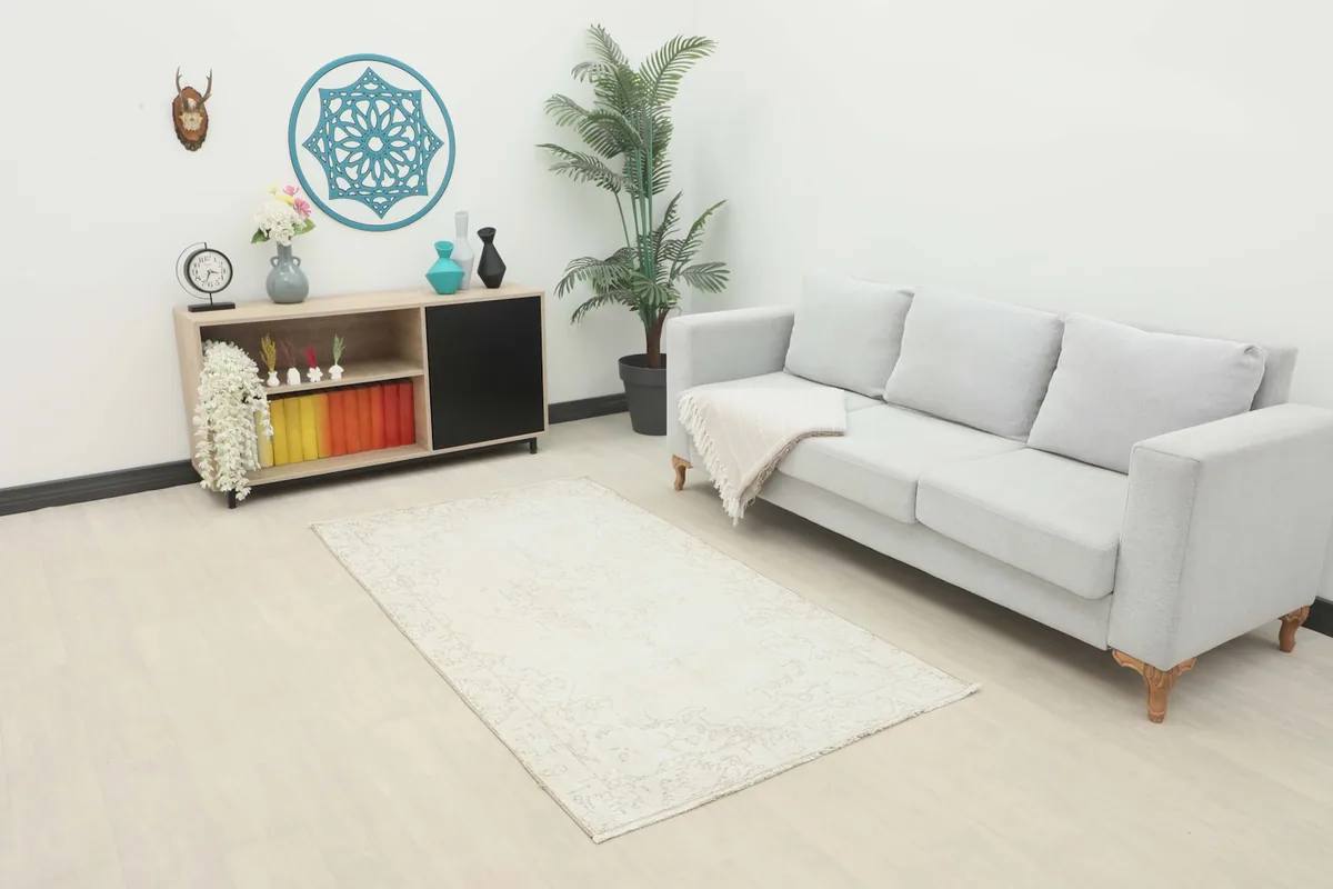 Ivory beige vintage rug in a modern living room setting with a light gray sofa and wooden furniture.