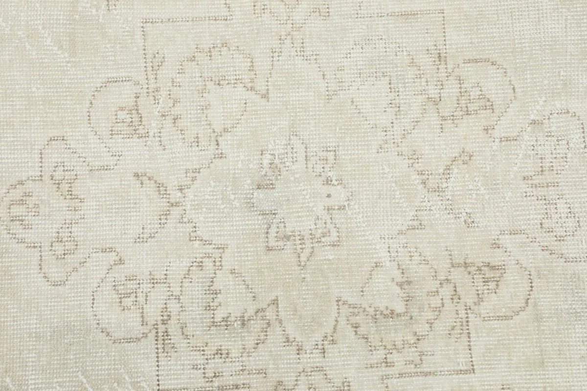 Detailed close-up of the hand-knotted wool pile, revealing the intricate beige medallion motif.
