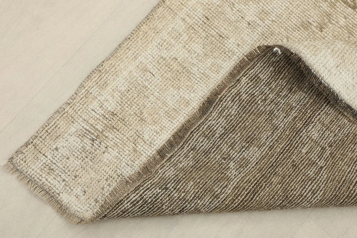 Folded corner of the rug, showcasing both the front and the sturdy cotton foundation