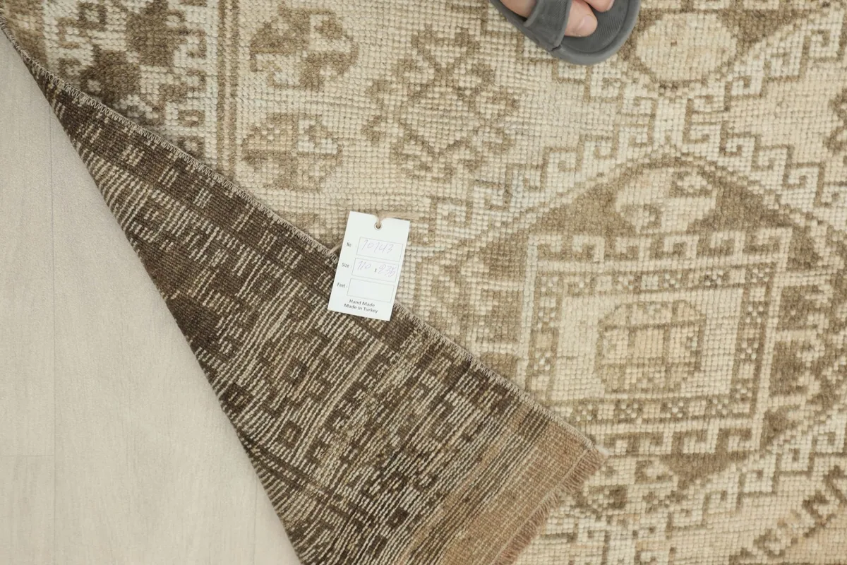 Overhead view of the rug with a tag, showing the detailed patterns and color variations
