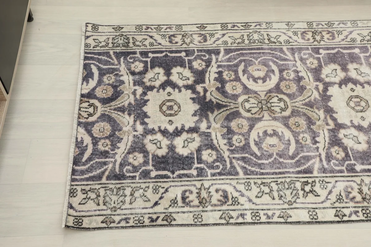 Angled view of the runner's end, with a side table in the background, detailing the pattern