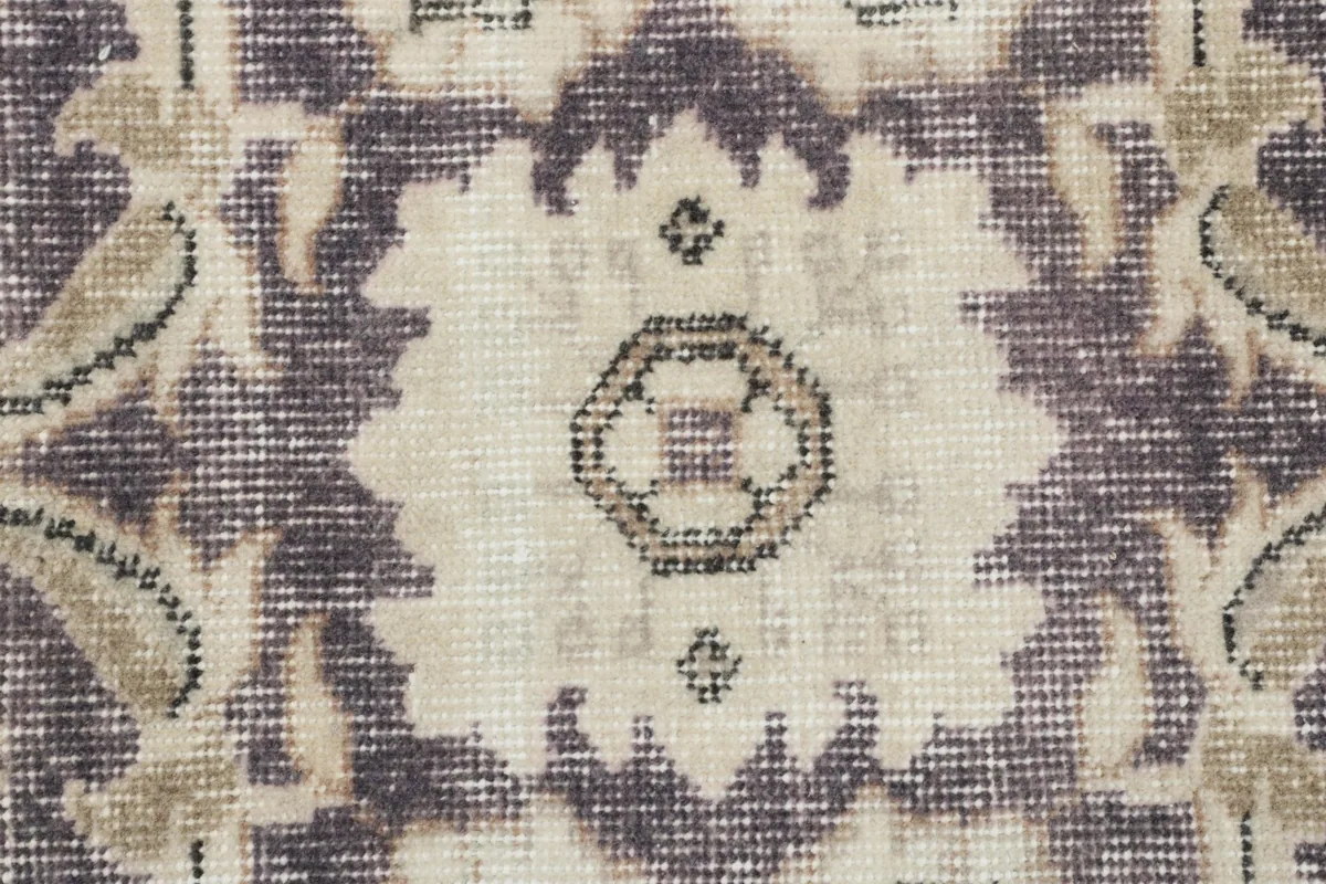 Close-up of a central floral medallion motif, showing texture and color variations in the wool pile