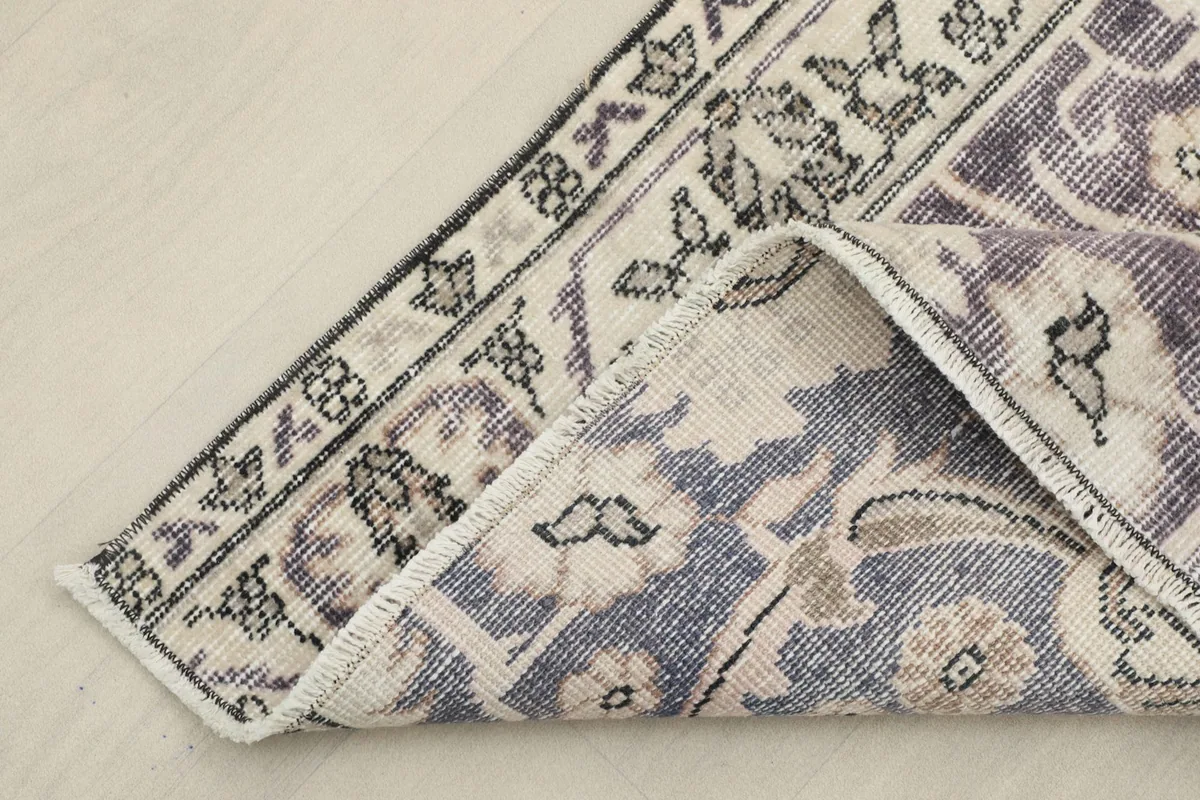 Corner of the runner folded to show the hand-knotted construction and cotton foundation on the reverse