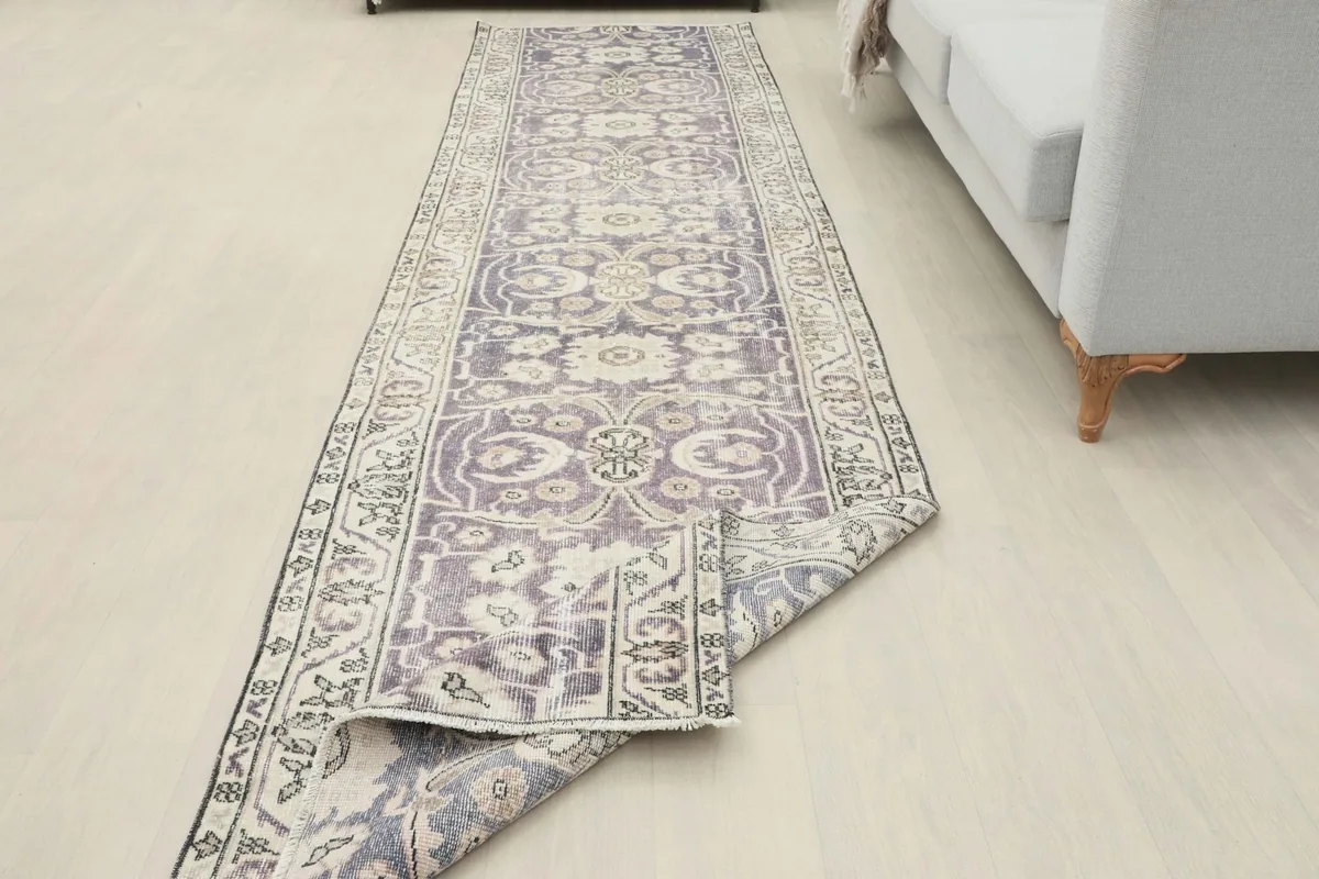Runner rug laid out with one end folded back, revealing the reverse side and overall length