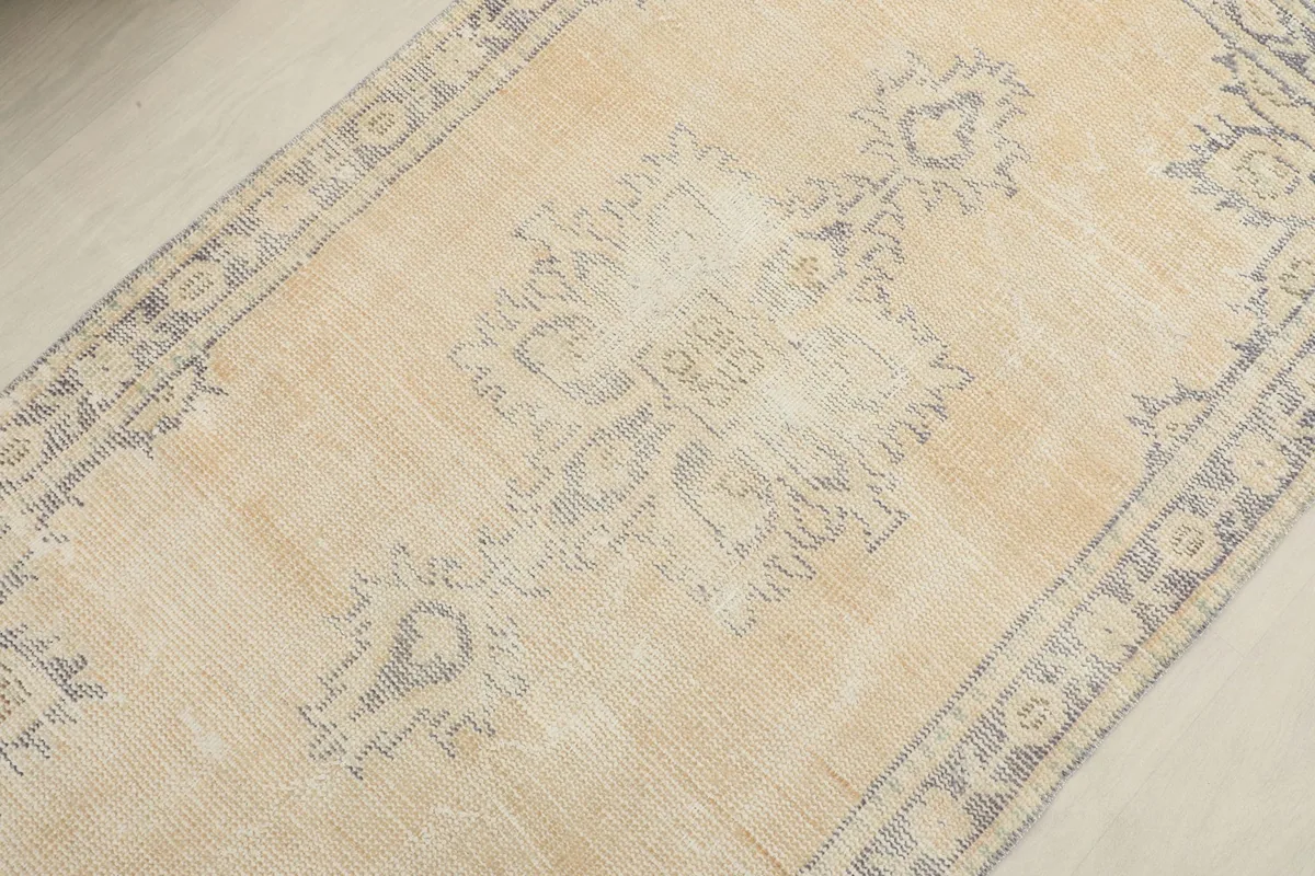 Detail view of the central medallion and surrounding geometric patterns in gray on the beige field