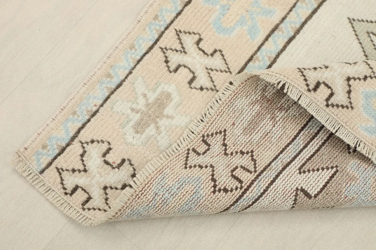 View of the rug's underside, revealing the hand-knotted cotton foundation and wool pile