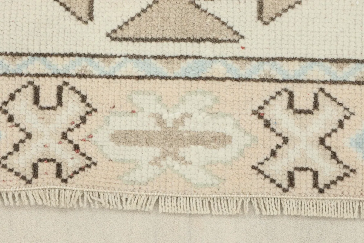 Detail of the rug's short, natural fringe and the patterns along the edge