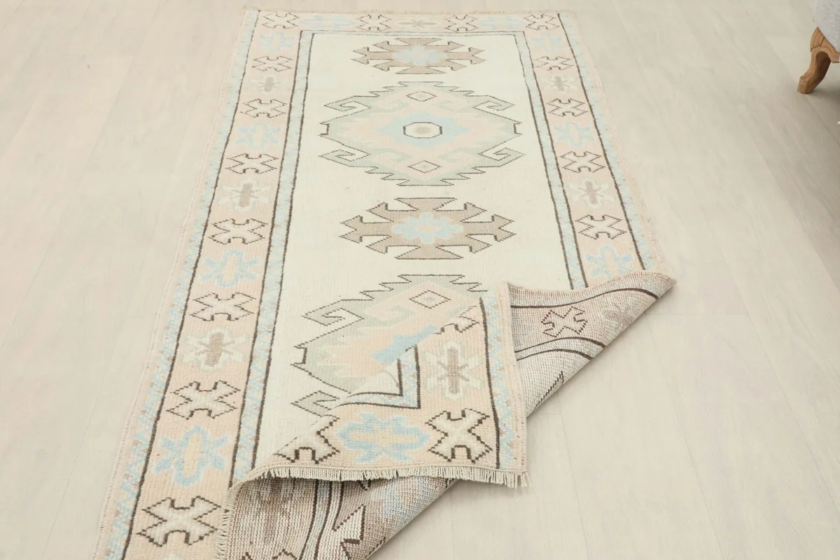 Long view of the rug with one end folded back, showing the thickness and construction