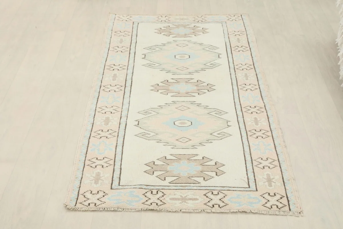 Full overhead view of the ivory blue geometric rug on a light floor, showing its entire length